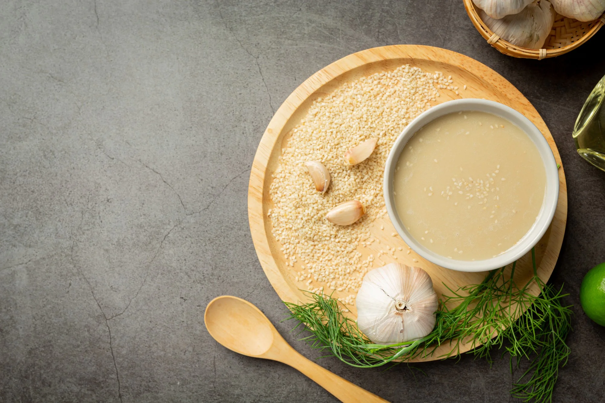 The picture of sesame flour poured into a bowl inside a wooden tray with decorations